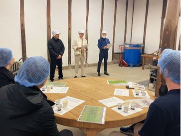 Participants attending a sake education session with tasting samples and course materials